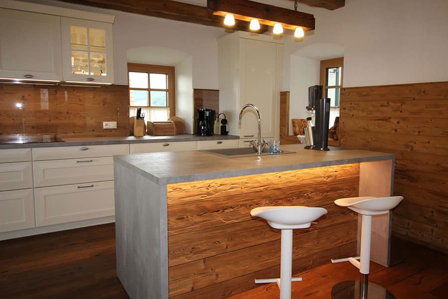 Landhausküche in weiß, Betonoptik, Kücheninsel, Echtholz Rückwand, LED-Beleuchtung, Eiche, Vertäfelung in Eiche